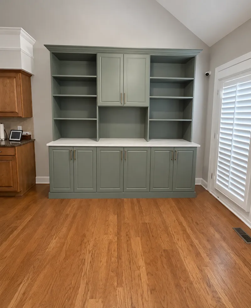 Sage green built-in hutch with open shelving, upper cabinets and a white countertop