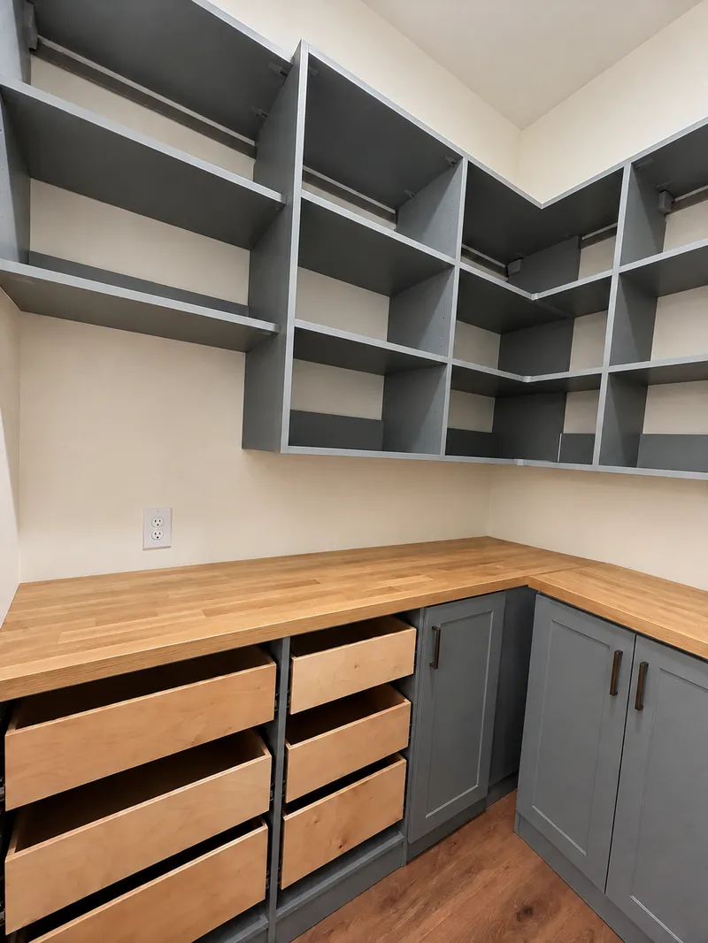 Pantry with gray open shelving, butcher-block countertops, maple drawers and shaker cabinets
