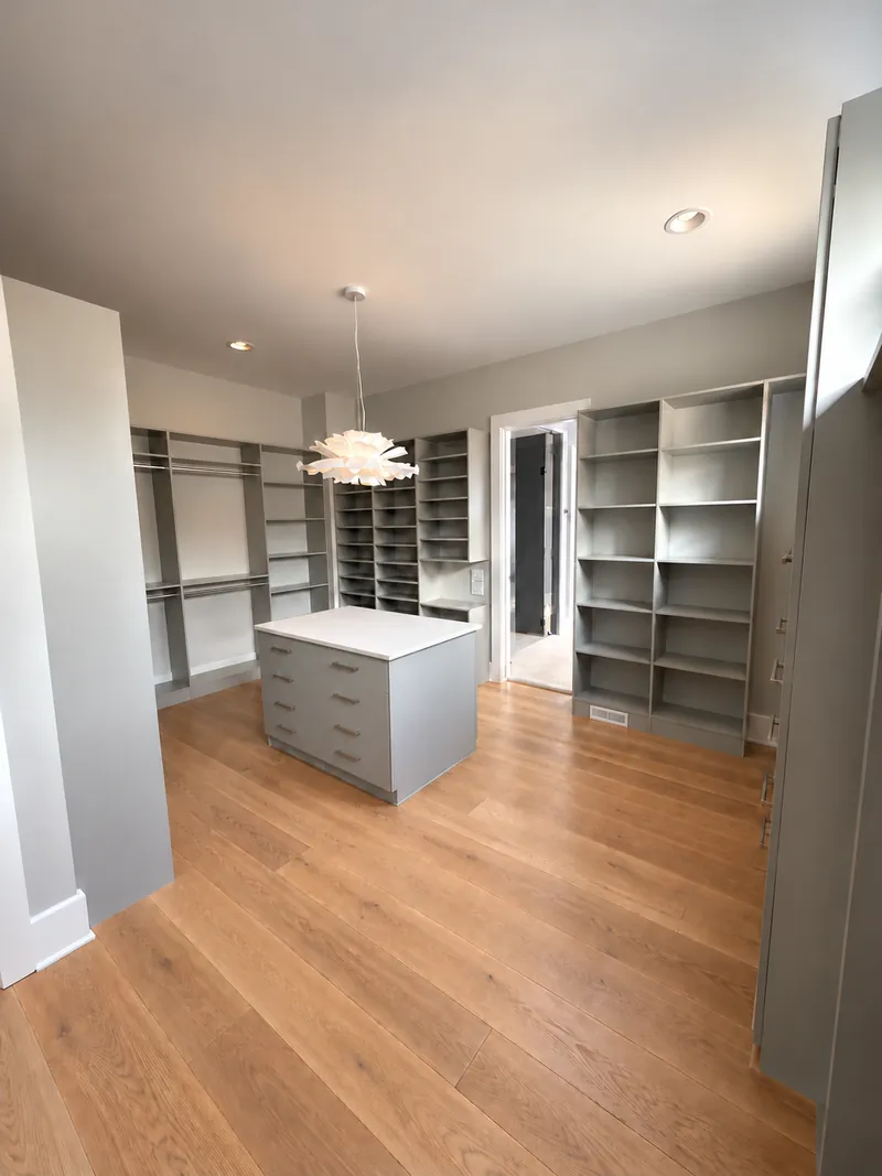 Walk-in closet in a gray finish with open shelving, hanging space and a center island
